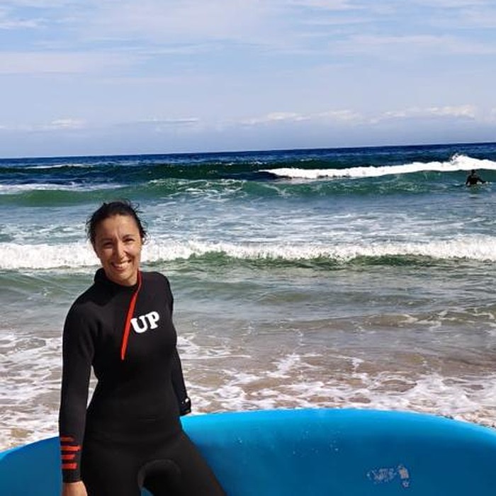 Patricia Pontón con una tabla de surf en la playa